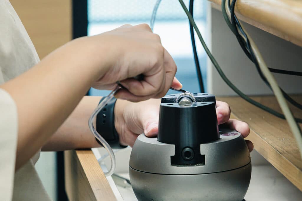 リングを機械に固定し、タガネで模様を彫っていく